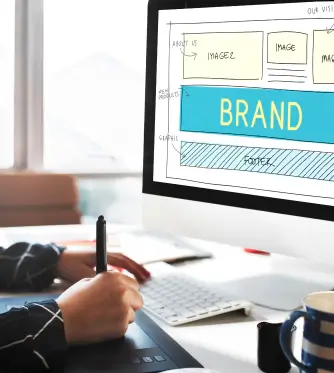 Person sketching a website design on a computer screen.